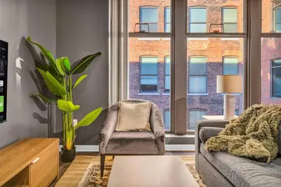 a living room with a couch and a chair at Comfy City Vibe • Walk to Theaters + Parking $ in Cleveland