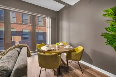 a dining room with a table and chairs and a couch at Comfy City Vibe • Walk to Theaters + Parking $ in Cleveland