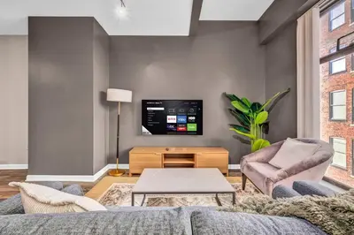 a living room with a couch and a tv at Comfy City Vibe • Walk to Theaters + Parking $ in Cleveland