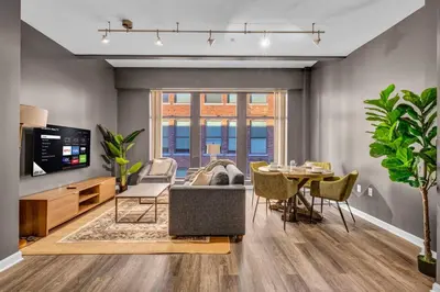 a living room with a couch and a table at Comfy City Vibe • Walk to Theaters + Parking $ in Cleveland