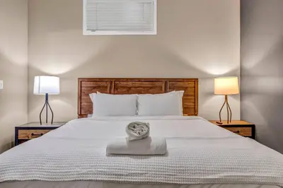 a white bed with a towel on it with two lamps at Play & Stay Loft Central, Comfy, Parking in Cleveland