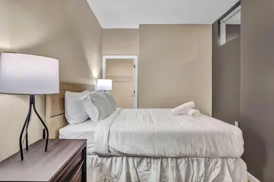 a bedroom with a bed and a table with a lamp at Play & Stay Loft Central, Comfy, Parking in Cleveland