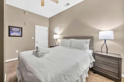a bedroom with a large white bed and a lamp at Play & Stay Loft Central, Comfy, Parking in Cleveland