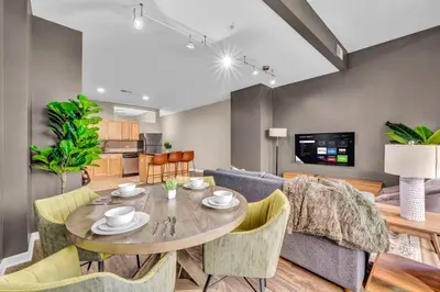 a dining room and living room with a table and chairs at Playhouse Square Suite | Downtown | Parking in Cleveland