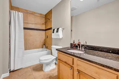 a bathroom with a sink and a toilet and a tub at Playhouse Square Suite | Downtown | Parking in Cleveland