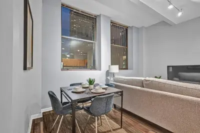 a living room with a table and chairs and a couch at Central Downtown Condo | Parking & Pool Table in Cleveland