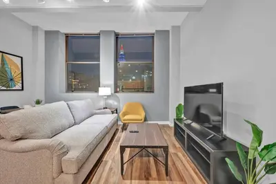 a living room with a couch and a flat screen tv at Central Downtown Flat near Attractions and more! in Cleveland