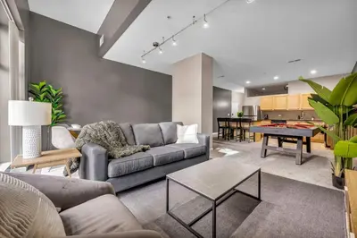 a living room with a couch and a table at Luxe Downtown Condo • Pool Table & Parking in Cleveland