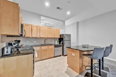 a kitchen with wooden cabinets and a counter top at Theater District Gem • Downtown Hideaway in Cleveland