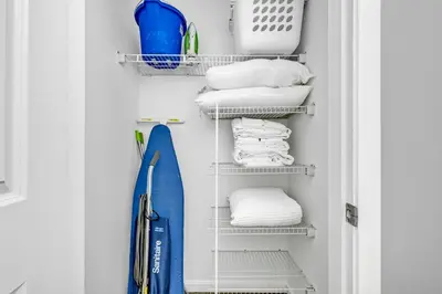 a closet with white towels and a blue surfboard at Stylish Condo • Walk to Theaters • Parking in Cleveland
