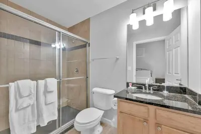 a bathroom with a shower and a toilet and a sink at Stylish Condo • Walk to Theaters • Parking in Cleveland
