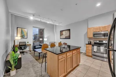 a kitchen with an island and a living room at Stylish Condo • Walk to Theaters • Parking in Cleveland
