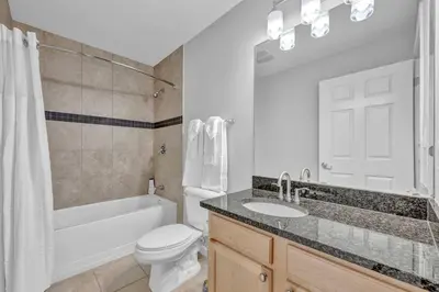 a bathroom with a white toilet and a sink and a tub at Stylish Condo • Walk to Theaters • Parking in Cleveland
