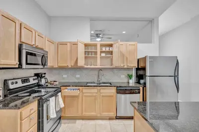 a kitchen with wooden cabinets and stainless steel appliances at The Playhouse Suites 2BD | Downtown | Security in Cleveland