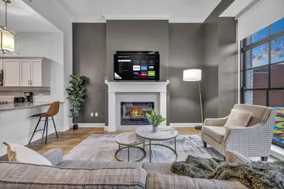 a living room with a couch and a fireplace at Warm and Cozy Downtown Flat: Paid Parking in Cleveland