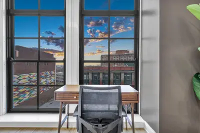 a desk with a chair in front of a window at Warm and Cozy Downtown Flat: Paid Parking in Cleveland