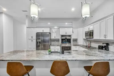 a kitchen with white cabinets and a granite counter top at Warm and Cozy Downtown Flat: Paid Parking in Cleveland
