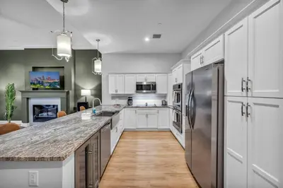 a kitchen with white cabinets and a stainless steel refrigerator at Stunning Luxury Downtown Condo in Playhouse Square in Cleveland