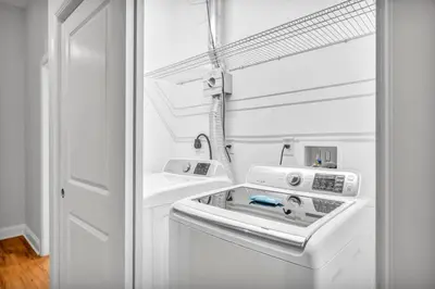 a white washer and dryer in a white kitchen at Stunning Luxury Downtown Condo in Playhouse Square in Cleveland