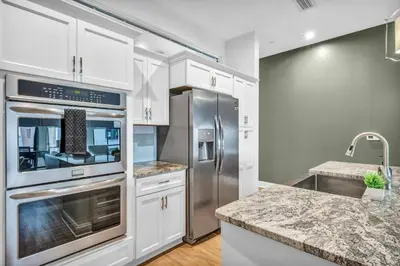 a kitchen with white cabinets and stainless steel appliances at Ultra Chic Condo in The Heart of Downtown! in Cleveland
