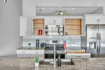 a kitchen with white cabinets and stainless steel appliances at Super LUX Downtown 1BD Condo | Gym | 24/7 Security in Cleveland