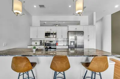 a kitchen with a large island with two bar stools at Super LUX Downtown 1BD Condo | Gym | 24/7 Security in Cleveland