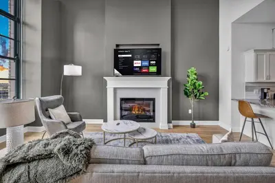a living room with a couch and a fireplace at Super LUX Downtown 1BD Condo | Gym | 24/7 Security in Cleveland
