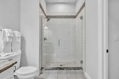 a white bathroom with a shower and a toilet at Luxury Condo Heart of Downtown | 98/100 Walk Score in Cleveland