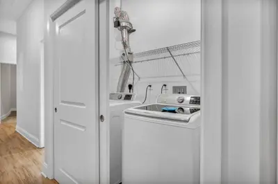 a white kitchen with a sink and a washing machine at Luxury Condo Heart of Downtown | 98/100 Walk Score in Cleveland