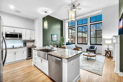 an open kitchen and living room with white cabinets at Luxury Condo Heart of Downtown | 98/100 Walk Score in Cleveland