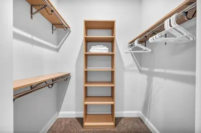 a walk in closet with wooden shelving and shelves at Luxury Condo Heart of Downtown | 98/100 Walk Score in Cleveland