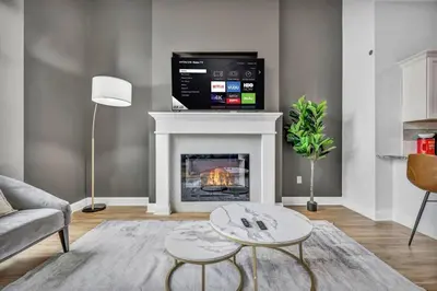 a living room with a fireplace with a tv above it at Premium Luxury Condo | Playhouse SQ | Parking $ in Cleveland