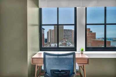 a desk with a chair in a room with windows at Premium Luxury Condo | Playhouse SQ | Parking $ in Cleveland