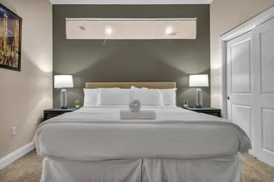 a bedroom with a large white bed with two lamps at Premium Luxury Condo | Playhouse SQ | Parking $ in Cleveland