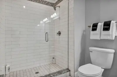 a white bathroom with a shower with a toilet at Premium Luxury Condo | Playhouse SQ | Parking $ in Cleveland