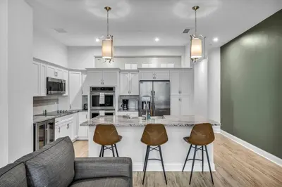 a kitchen with white cabinets and a couch and chairs at Luxury Condo in Playhouse Square: Walkers Paradise in Cleveland