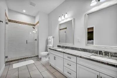 a white bathroom with two sinks and a shower at Luxury Condo in Playhouse Square: Walkers Paradise in Cleveland
