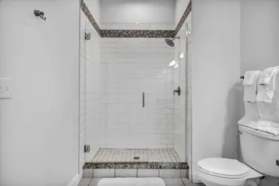 a white bathroom with a shower with a toilet at Luxury Condo in Playhouse Square: Walkers Paradise in Cleveland