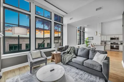a living room with a couch and chairs and windows at The Halle Downtown 2BD | Parking/Gym/Security in Cleveland