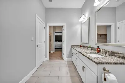 a white bathroom with two sinks and a mirror at The Halle Downtown 1BD | Parking/Gym/Security in Cleveland