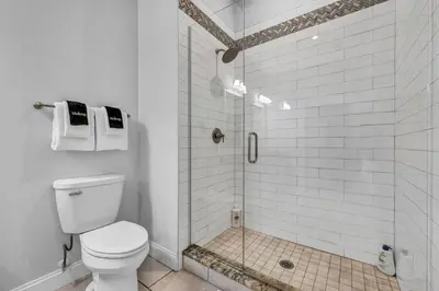 a white bathroom with a shower with a toilet at The Halle Downtown 1BD | Parking/Gym/Security in Cleveland