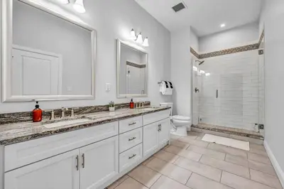 a white bathroom with two sinks and a toilet at The Halle Downtown | Parking/Gym/Security A2 in Cleveland