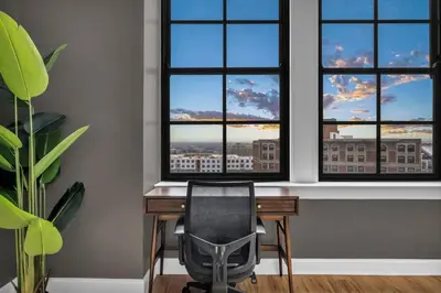 a desk with a chair in a room with windows at The Halle Downtown | Parking/Gym/Security A2 in Cleveland