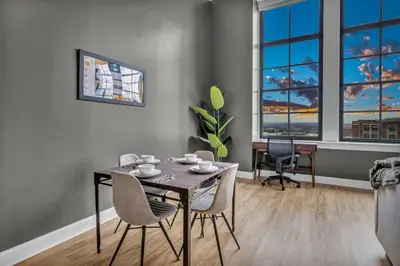 a dining room with a table and chairs and a desk at The Halle Downtown | Parking/Gym/Security A2 in Cleveland