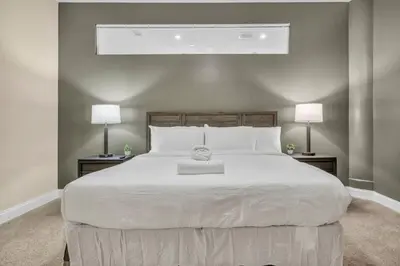 a bedroom with a large white bed with two lamps at The Halle Downtown | Parking/Gym/Security A2 in Cleveland