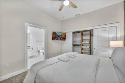 a white bedroom with a bed and a ceiling fan at Downtown Luxury ~ King bed ~ Paid Parking ~ Wi-Fi in Cleveland