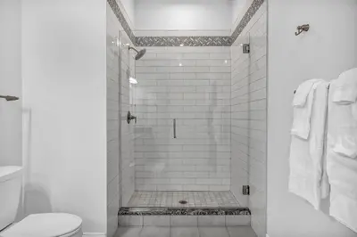 a white bathroom with a shower with a toilet at HUGE Luxury Flat in Playhouse Square | Downtown in Cleveland