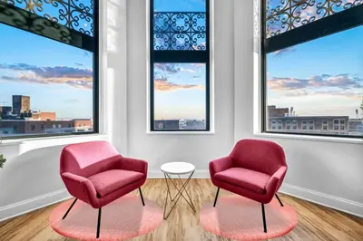 two chairs and a table in a room with windows at HUGE Luxury Flat in Playhouse Square | Downtown in Cleveland