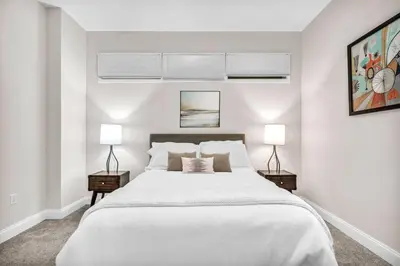 a white bedroom with a large bed and two lamps at HUGE Luxury Flat in Playhouse Square | Downtown in Cleveland