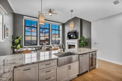 a kitchen with a sink and a living room at Lux Flat Overlooking Guardians Field! Parking $ in Cleveland